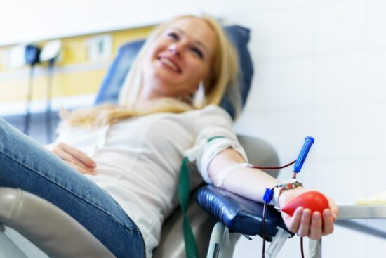 Woman sitting in a chair donating plasma