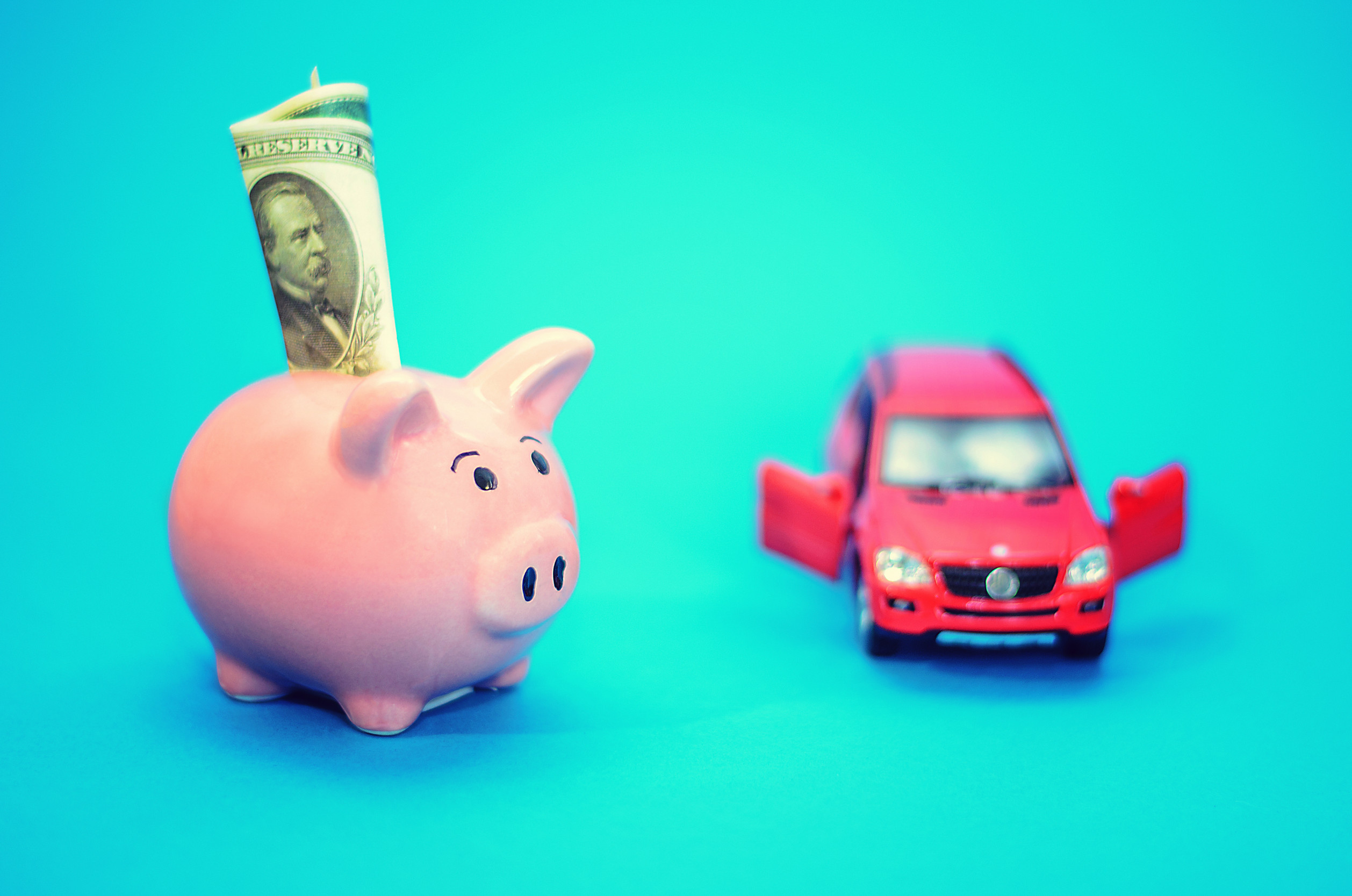 The Pink Piggy bank with a car on the table. Has been released. The idea of ​​saving money and donations to the property.